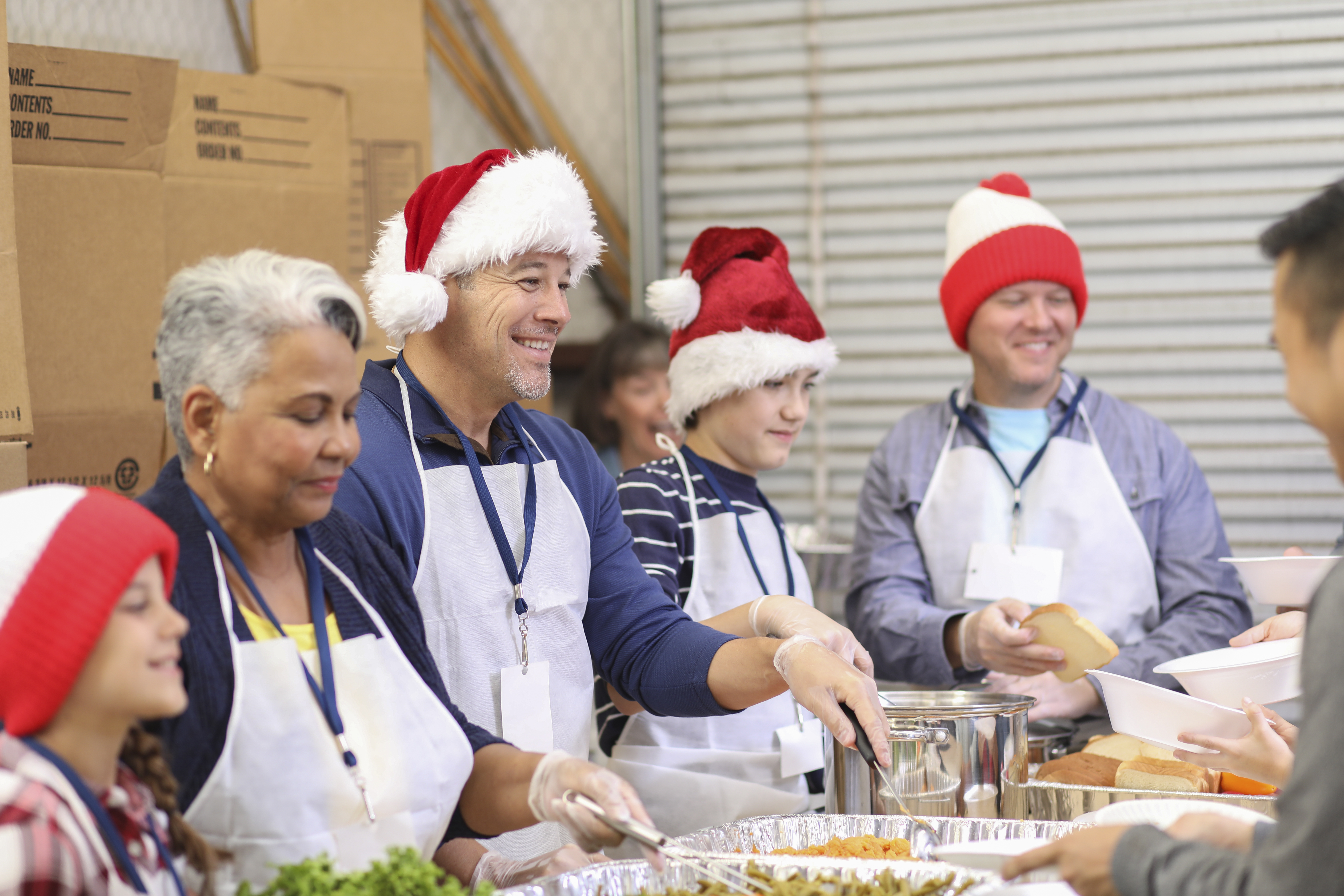 Multi Ethnic Volunteers Serves Food At Soup Kitchen At Christmas
